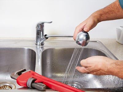 A photo of a whitehouse plumber working on a faucet repair.