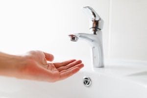 An image of a hand under a low water pressure sink.