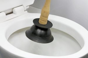 using a plunger to fix a leaking toilet 